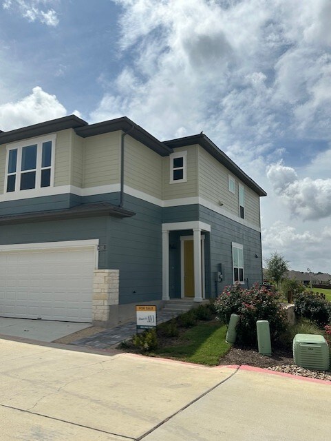 view of front of property featuring a garage and central AC unit