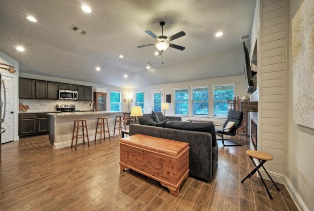 living room with dark hardwood / wood-style floors, ceiling fan, and lofted ceiling