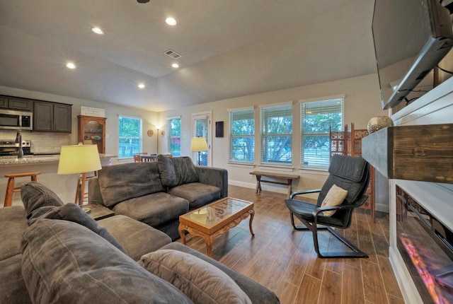 21707 Crystal Way, Lago Vista, TX 78645 - living area with healthy amount of natural light, vaulted ceiling, recessed lighting, dark wood-style floors, and baseboards