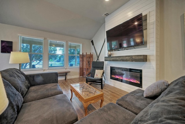 21707 Crystal Way, Lago Vista, TX 78645 - living area with a glass covered fireplace, wood finished floors, baseboards, vaulted ceiling, and recessed lighting