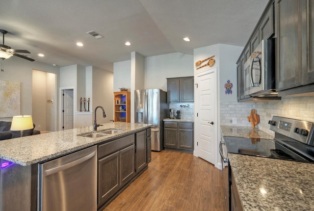 21707 Crystal Way, Lago Vista, TX 78645 - kitchen with appliances with stainless steel finishes, a sink, wood finished floors, a kitchen island with sink, and open floor plan