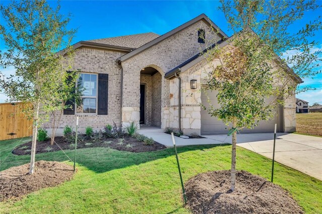 607 Breeze Hollow Ln, Georgetown, TX 78628 - french country home featuring an attached garage, driveway, brick siding, and stone siding