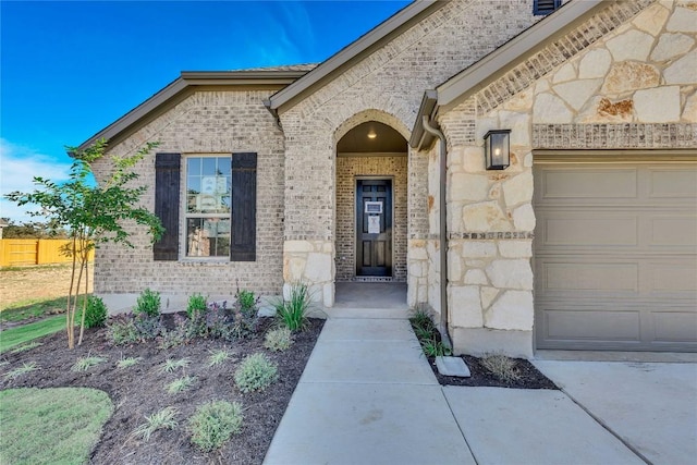 607 Breeze Hollow Ln, Georgetown, TX 78628 - view of exterior entry featuring brick siding, an attached garage, and stone siding