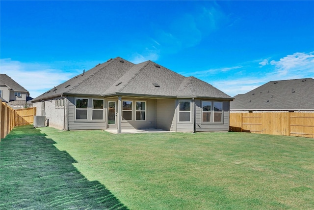 rear view of property with a yard, a patio, and central AC unit