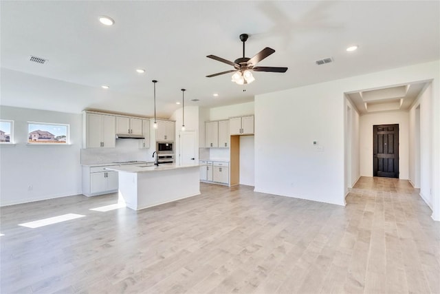 607 Breeze Hollow Ln, Georgetown, TX 78628 - kitchen with stainless steel microwave, electric stovetop, light countertops, a center island with sink, and recessed lighting