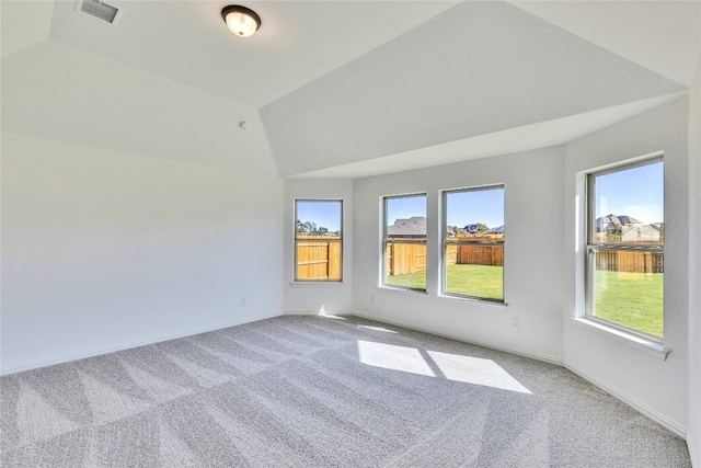 carpeted spare room with lofted ceiling