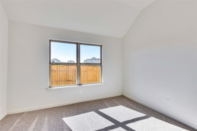 empty room with carpet flooring and vaulted ceiling