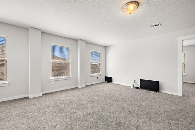 unfurnished living room with a textured ceiling and carpet flooring