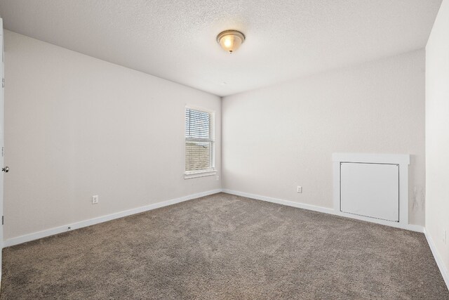 carpeted spare room with a textured ceiling