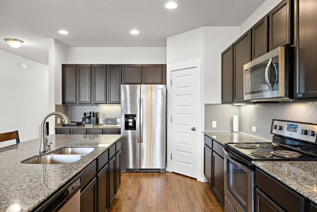 kitchen with decorative backsplash, dark hardwood / wood-style flooring, appliances with stainless steel finishes, and sink