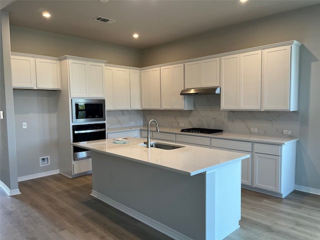 kitchen with a kitchen island with sink, sink, stainless steel appliances, and white cabinets