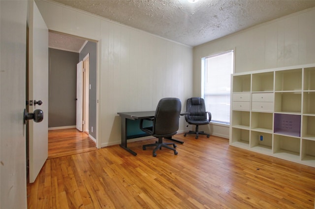 unfurnished office with wood-type flooring, a textured ceiling, and plenty of natural light