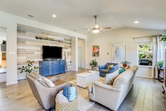 living room with light hardwood / wood-style flooring, ceiling fan, and vaulted ceiling