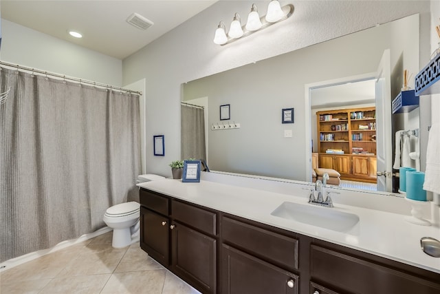 bathroom with vanity, curtained shower, toilet, and tile patterned flooring