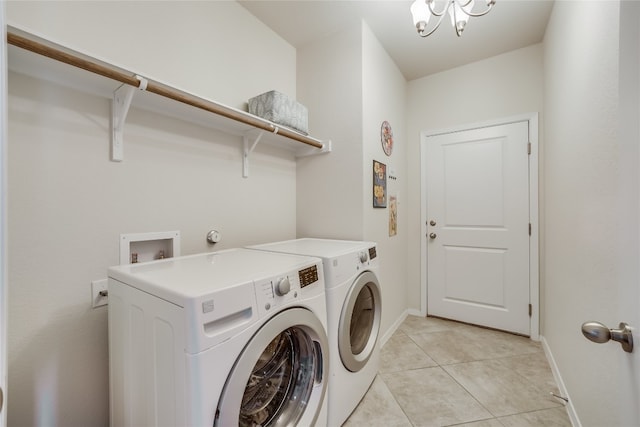 clothes washing area featuring an inviting chandelier, independent washer and dryer, and light tile patterned floors