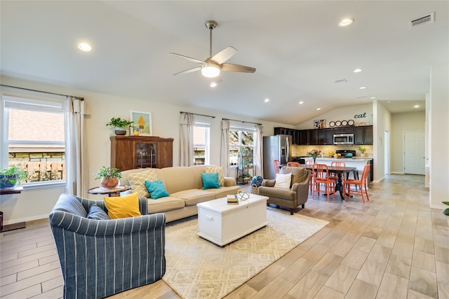 living room featuring light hardwood / wood-style floors, lofted ceiling, and ceiling fan