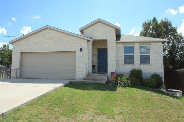 view of front of property with a garage and a front lawn