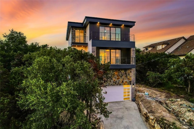 15000 Texas St, Austin, TX 78734 - contemporary house with a balcony, a garage, concrete driveway, and stone siding