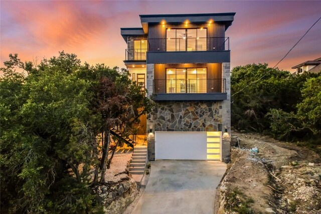 contemporary home featuring a balcony and a garage