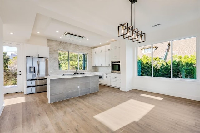15000 Texas St, Austin, TX 78734 - kitchen featuring stainless steel appliances, a kitchen island, white cabinetry, light countertops, and tasteful backsplash