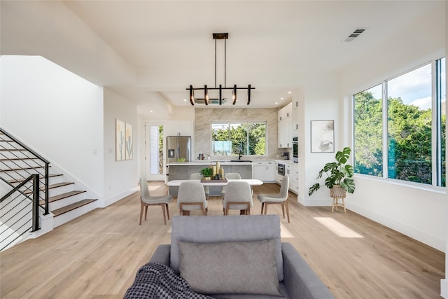 15000 Texas St, Austin, TX 78734 - living room featuring stairway, baseboards, light wood-type flooring, a chandelier, and recessed lighting