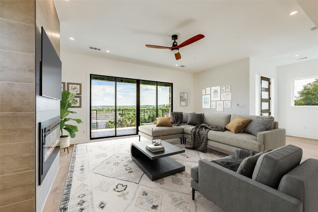 living room with light hardwood / wood-style floors and ceiling fan