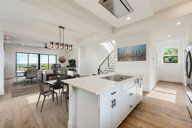 15000 Texas St, Austin, TX 78734 - kitchen with black electric stovetop, light wood-style flooring, a kitchen island, a desk, and white cabinets