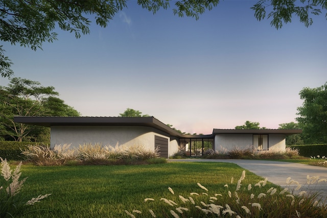 property exterior at dusk with a lawn and a garage