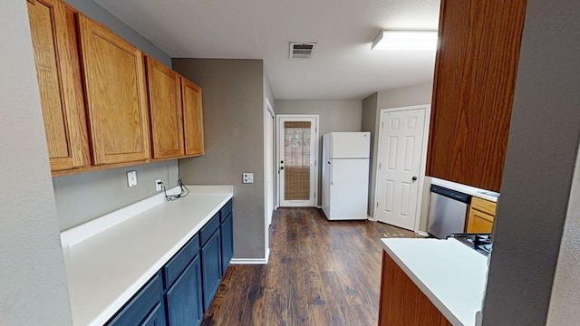 kitchen with stainless steel dishwasher, white fridge, and dark wood-type flooring