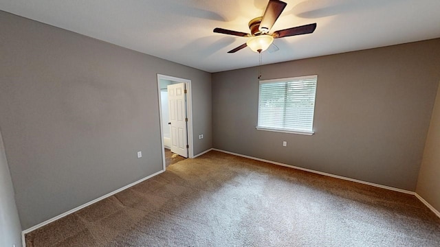 empty room featuring ceiling fan and carpet