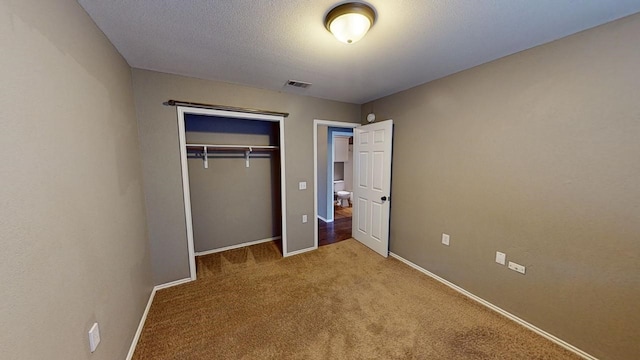 unfurnished bedroom with light carpet and a closet