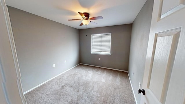 spare room with ceiling fan and light carpet