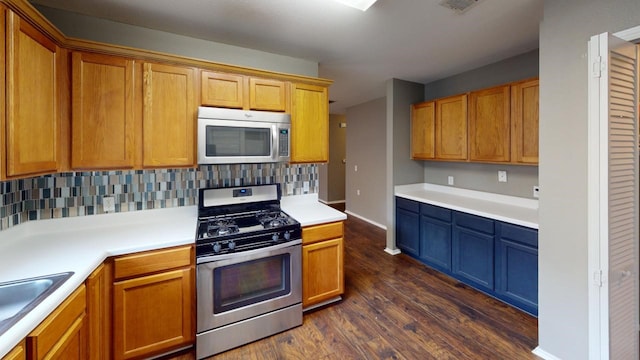 kitchen featuring sink, dark hardwood / wood-style flooring, appliances with stainless steel finishes, and tasteful backsplash