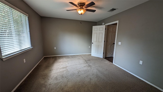 empty room featuring ceiling fan and carpet