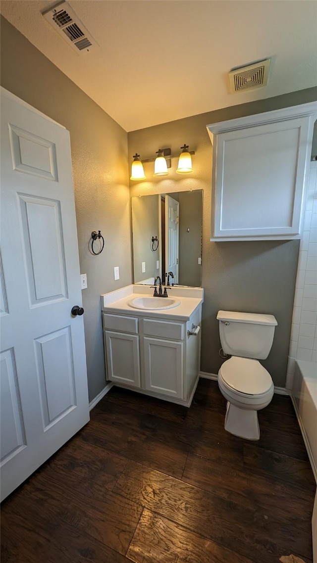 bathroom featuring vanity, toilet, a bathtub, and wood-type flooring