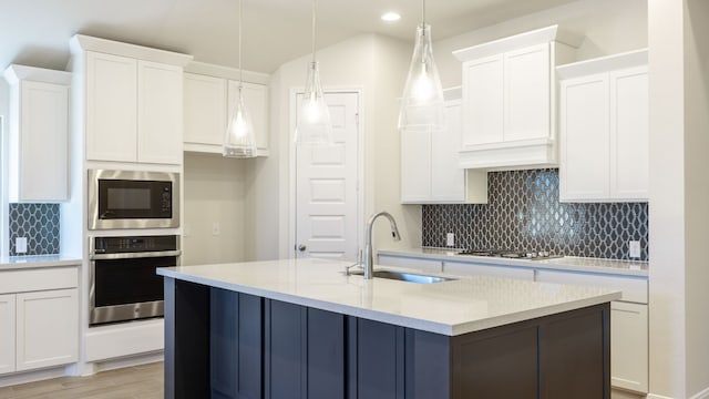 kitchen featuring appliances with stainless steel finishes, white cabinets, and sink