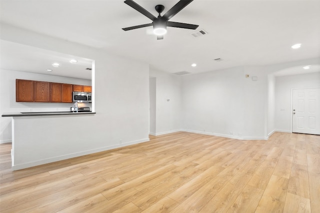 unfurnished living room with light wood-type flooring and ceiling fan