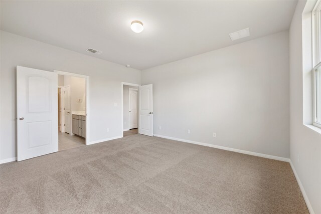 unfurnished bedroom with light carpet and ensuite bathroom