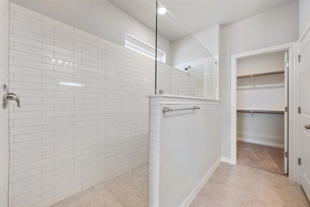 bathroom with tile patterned floors and tiled shower