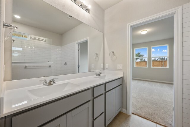 bathroom featuring vanity, a tile shower, and tile patterned floors