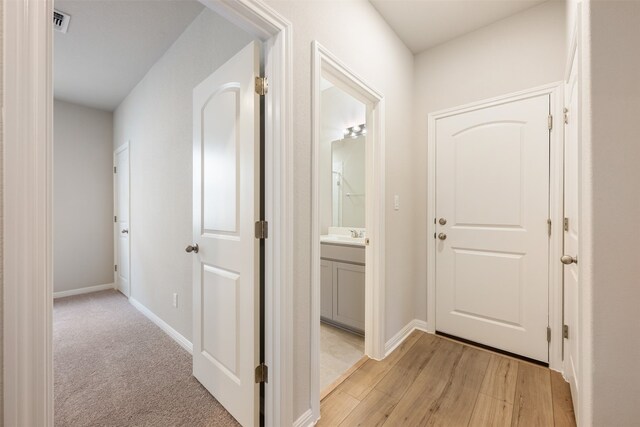 hall featuring sink and light wood-type flooring