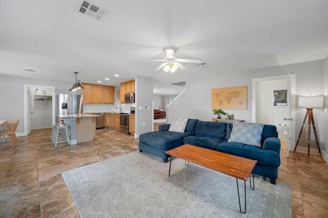 living room with ceiling fan and sink