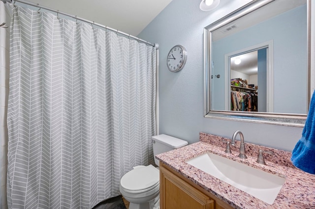 bathroom featuring toilet, vanity, and a shower with shower curtain