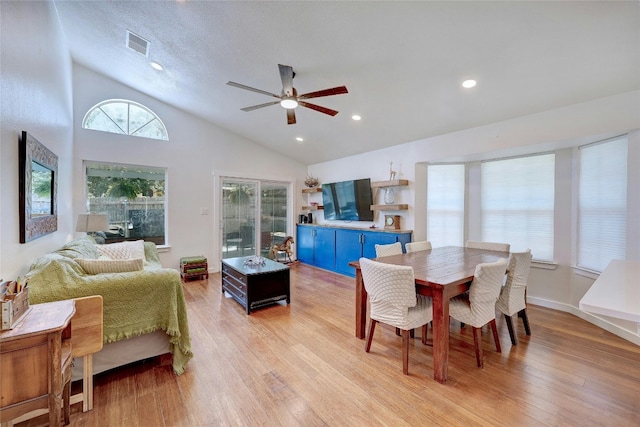 dining space featuring high vaulted ceiling, a textured ceiling, ceiling fan, and light hardwood / wood-style flooring