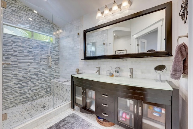 bathroom featuring tile walls, decorative backsplash, tile patterned flooring, vanity, and an enclosed shower