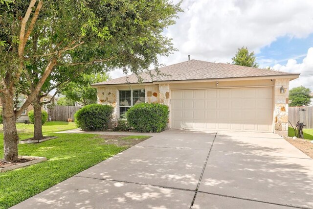 ranch-style house featuring a garage and a front yard