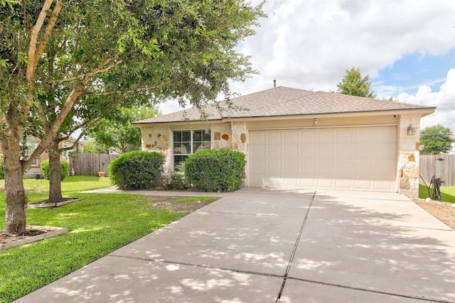 single story home with a front yard, fence, a garage, stone siding, and driveway