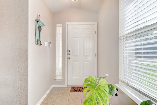 foyer entrance with vaulted ceiling and light tile patterned floors