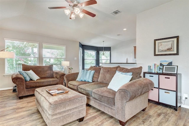 living room with vaulted ceiling, a wealth of natural light, light wood-type flooring, and ceiling fan