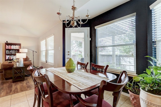 dining space featuring an inviting chandelier, vaulted ceiling, and light tile patterned floors